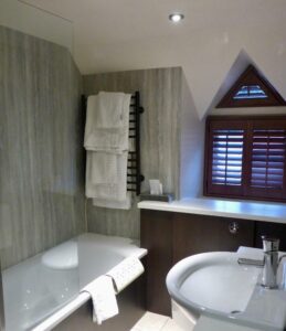 Badkamer in Iers hotel met ligbad, wastafel en dakraam