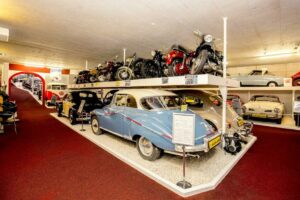 Museumruimte met klassieke auto’s en motorfietsen op meerdere niveaus