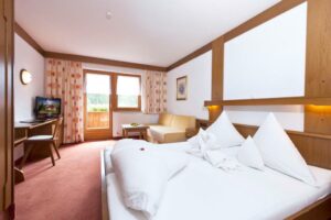 Ruime hotelkamer met balkon en zithoek