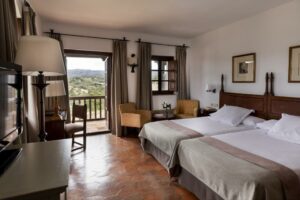 Hotelkamer met twee bedden en balkon