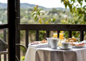 Ontbijttafel met koffie en broodjes op terras