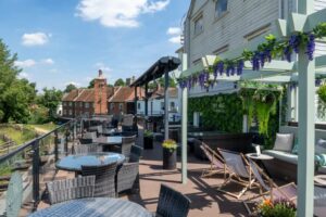 terras in de zon met pergola en strandstoelen