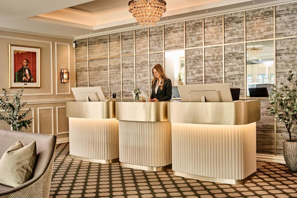 Moderne hotelreceptie met balie, verlichting en medewerker