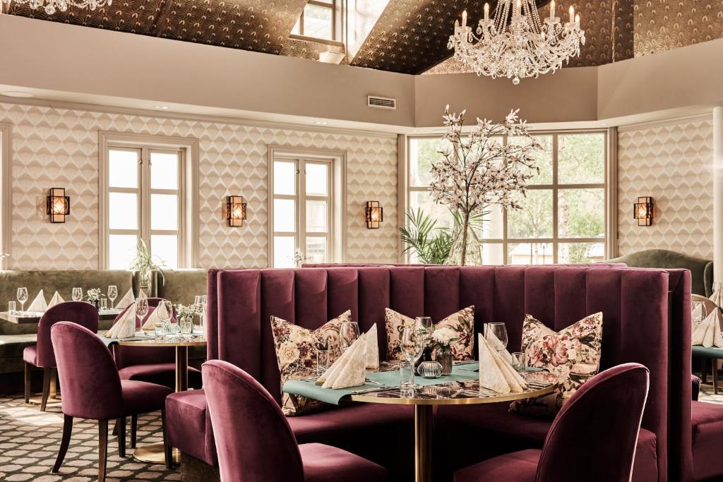 Sfeervol restaurant met ronde tafels, bankzitplaatsen en kroonluchter