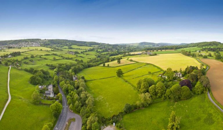 Luchtfoto van groen landschap met velden, bomen en wegen