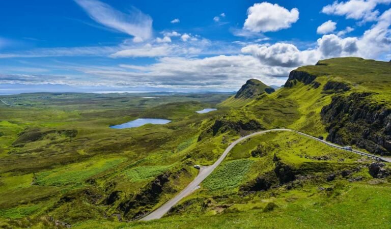 Bochtige bergweg door groen heuvelachtig landschap op Isle of Skye in Schotland