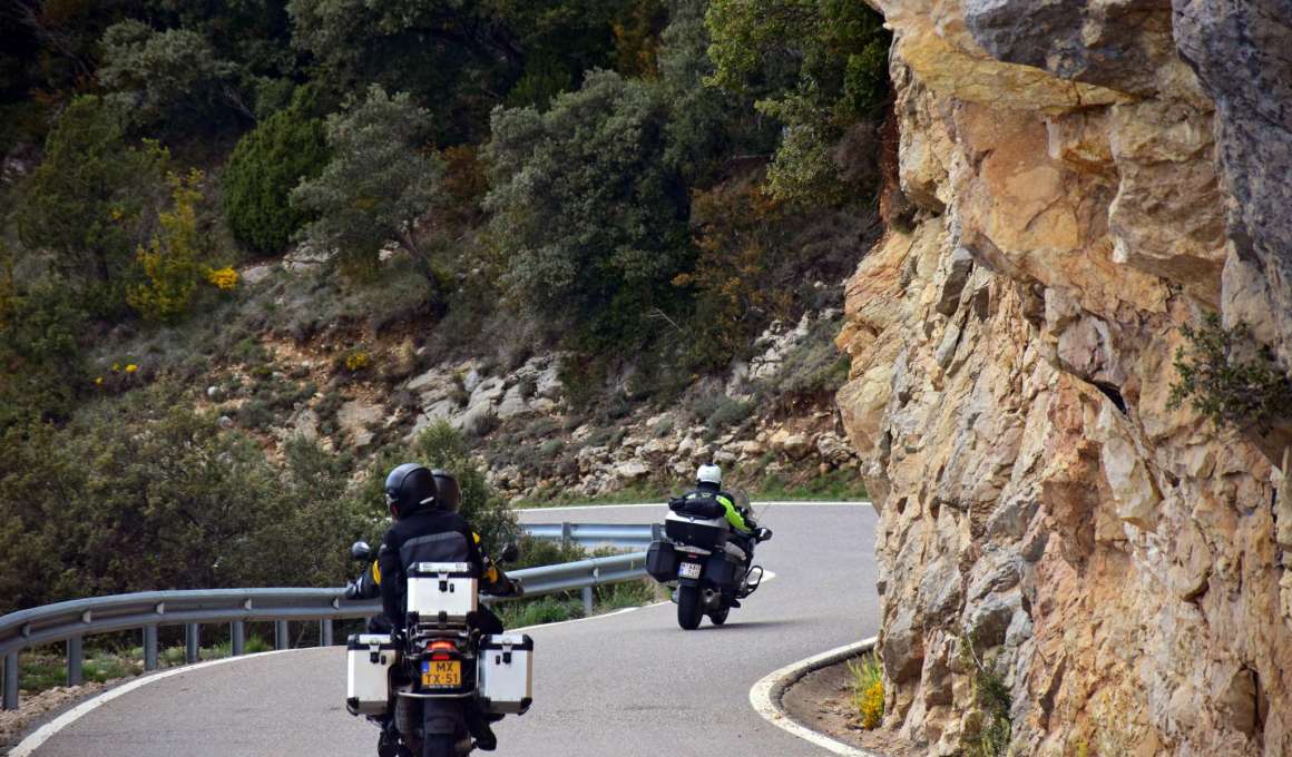 Motorrijders volgen een bochtige weg langs rotsachtig terrein