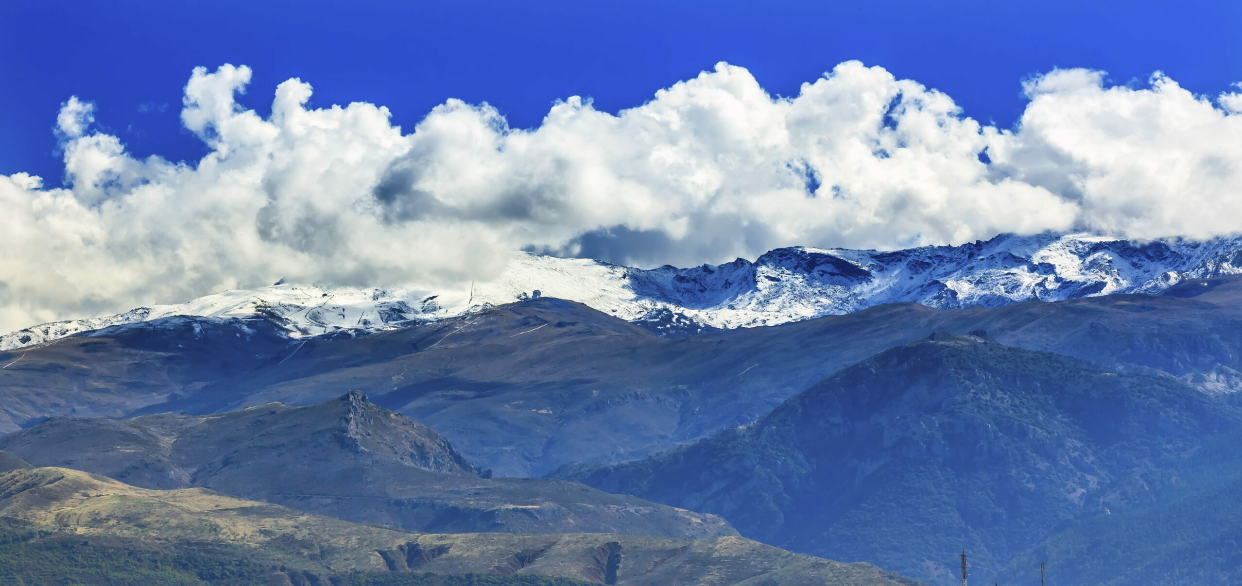 Berglandschap met besneeuwde toppen en wolken in de Sierras bij Sevilla