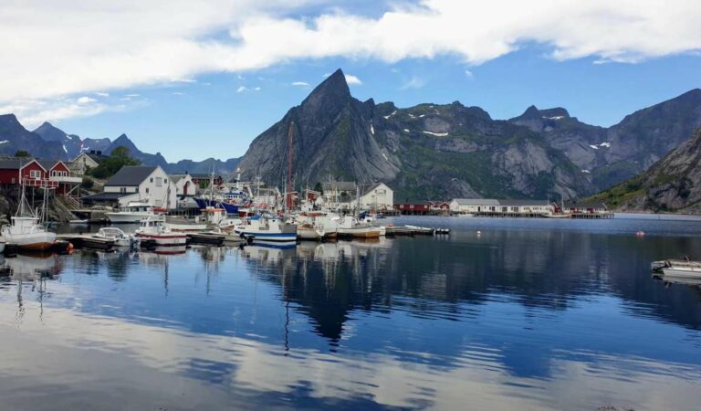 Kleine haven met vissersboten en steile bergen rondom het water