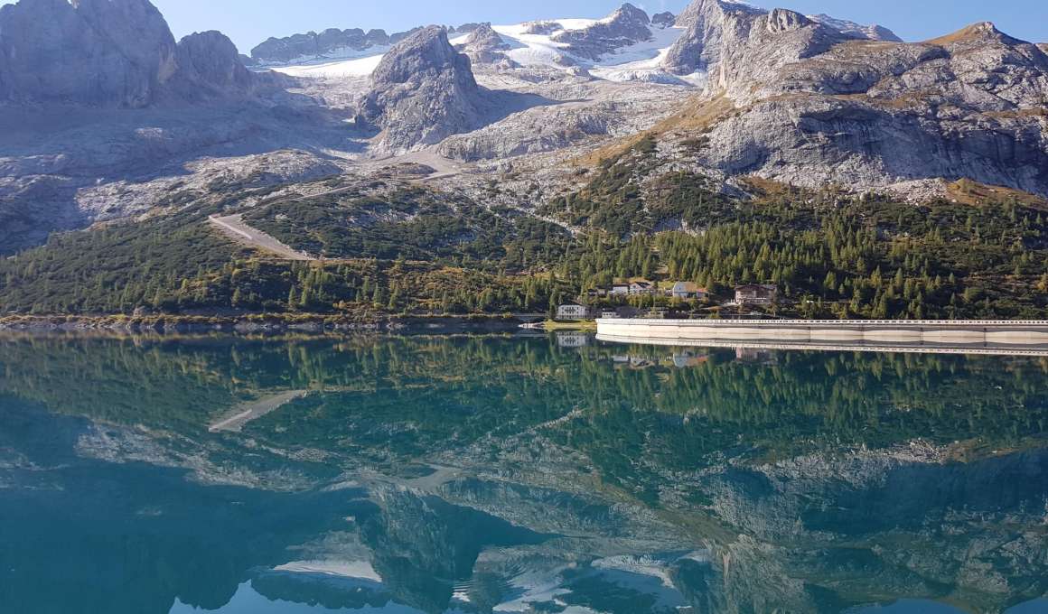 Bergmeer met weg en rotsachtige bergen bij Passo di Fedaia in Italië