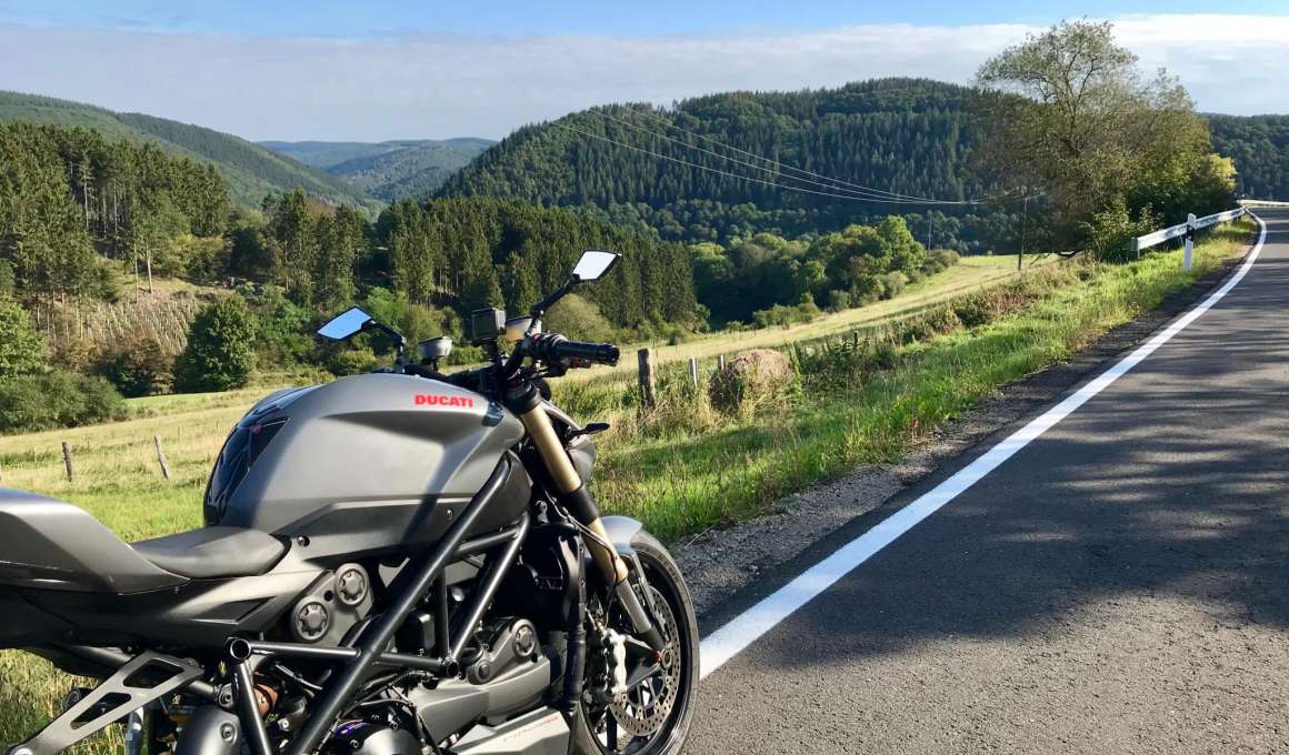 Motorfiets langs de weg in bochtachtig boslandschap