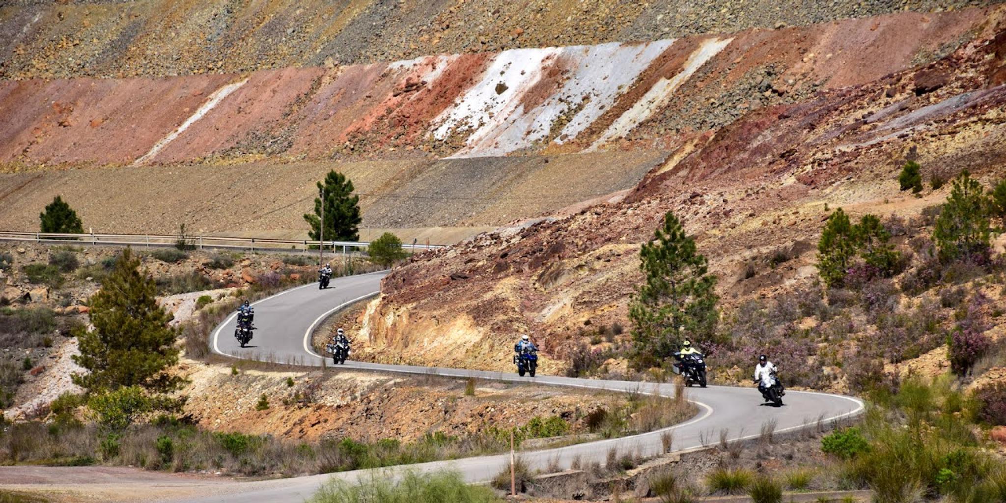 Groep motorrijders op een bochtige weg in heuvelachtig landschap in Andalusië