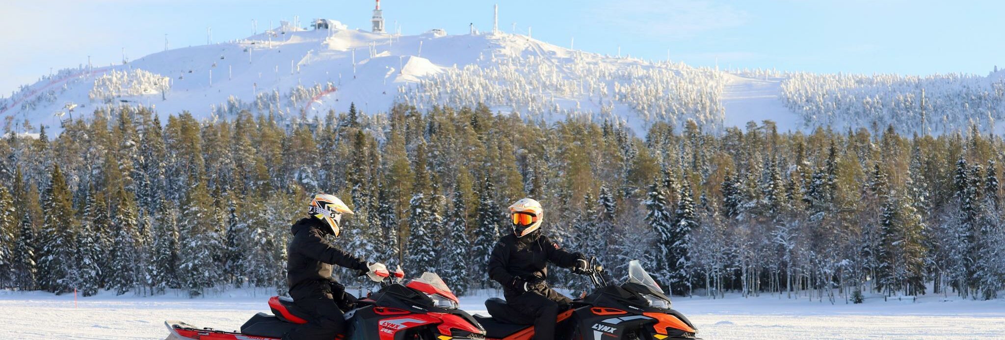 Sneeuwscooterrijders in Fins Lapland met winterlandschap