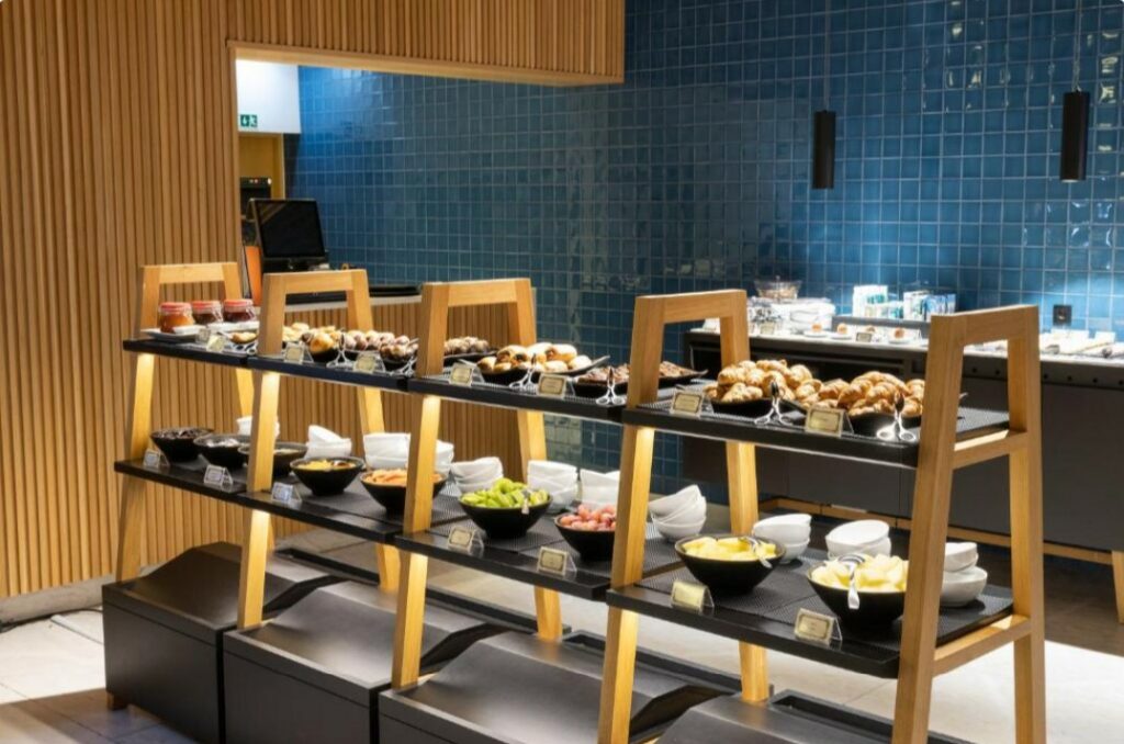 Opstelling van een ontbijtbuffet met broodjes, fruit en schaaltjes