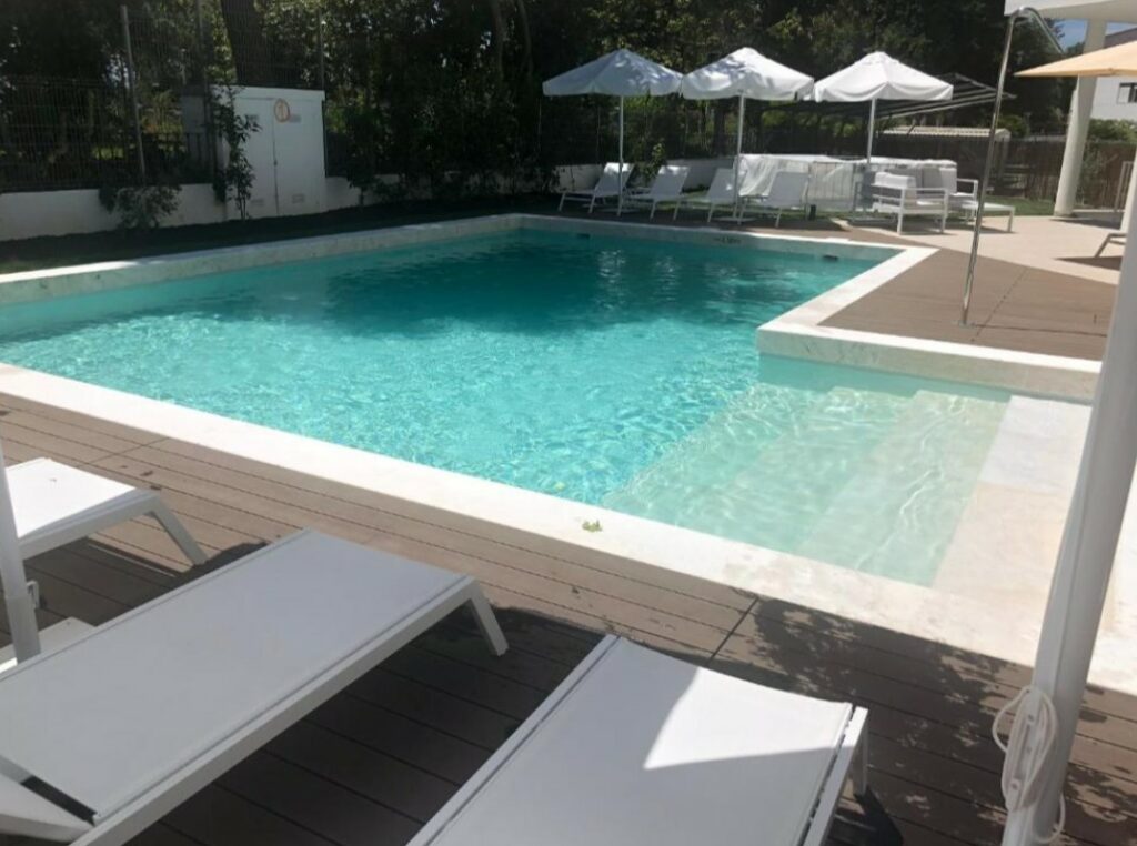Ligstoelen en parasols bij het zwembad van hotel Olive in Evora