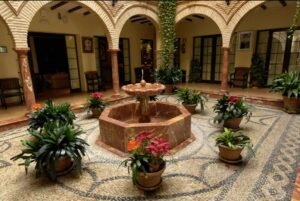 Binnenplaats met centrale fontein, bogen en planten in potten