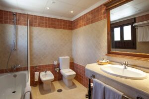 Badkamer met ligbad, toilet, bidet en wastafel met spiegel