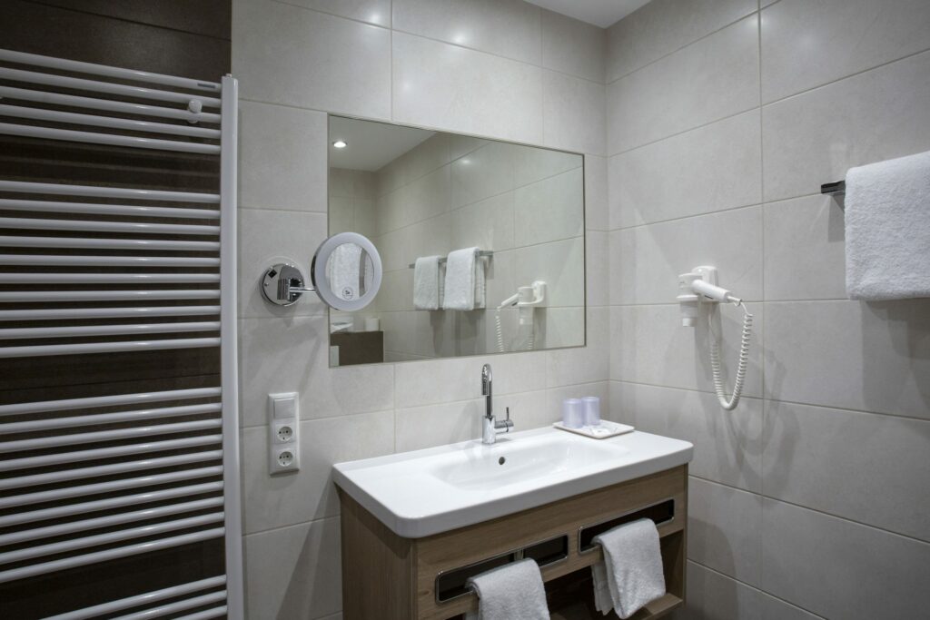 Badkamer met wastafel, spiegel en handdoeken