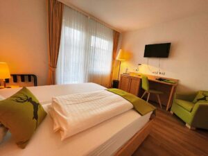 Hotelkamer met bureau, zitstoel en tweepersoonsbed
