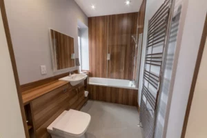 Strakke hotelbadkamer met houtaccenten en ligbad langs de North Coast 500