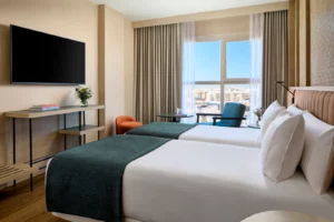 Moderne hotelkamer met twee bedden en groot raam