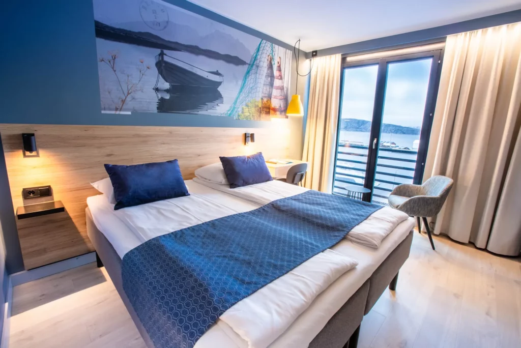Hotelkamer met tweepersoonsbed en balkon met uitzicht