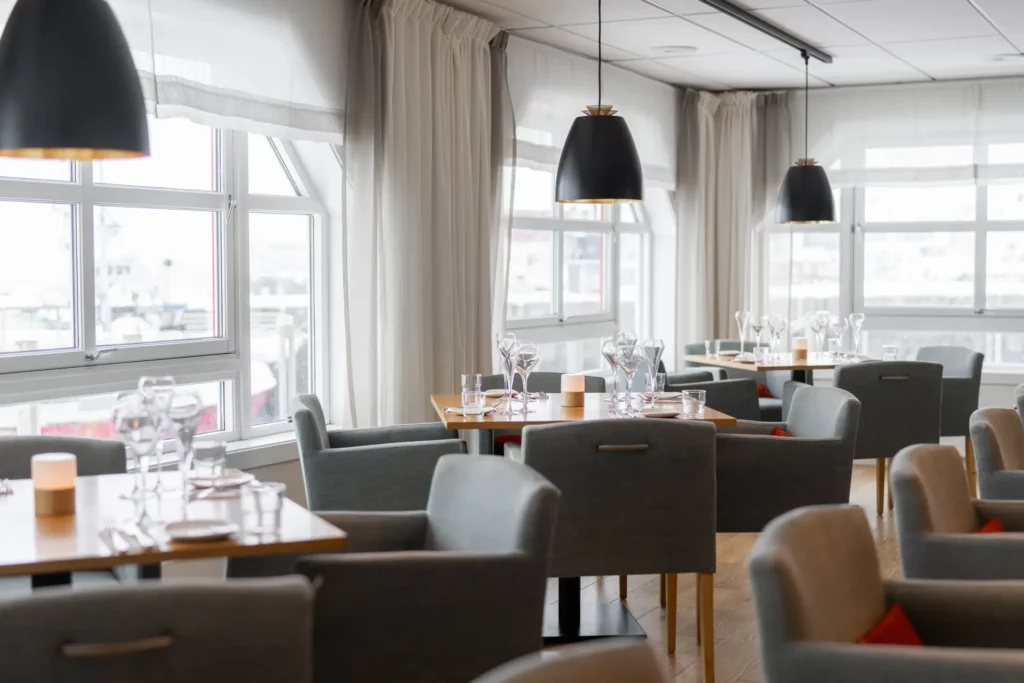 Licht restaurantinterieur met gedekte tafels en grote ramen
