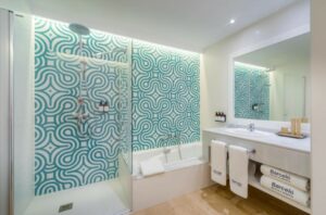 Moderne badkamer met ligbad, douchewand, wastafel en spiegel