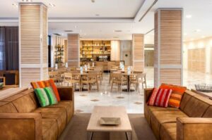 Ruime restaurantzaal met tafels, stoelen en zitgedeelte met banken