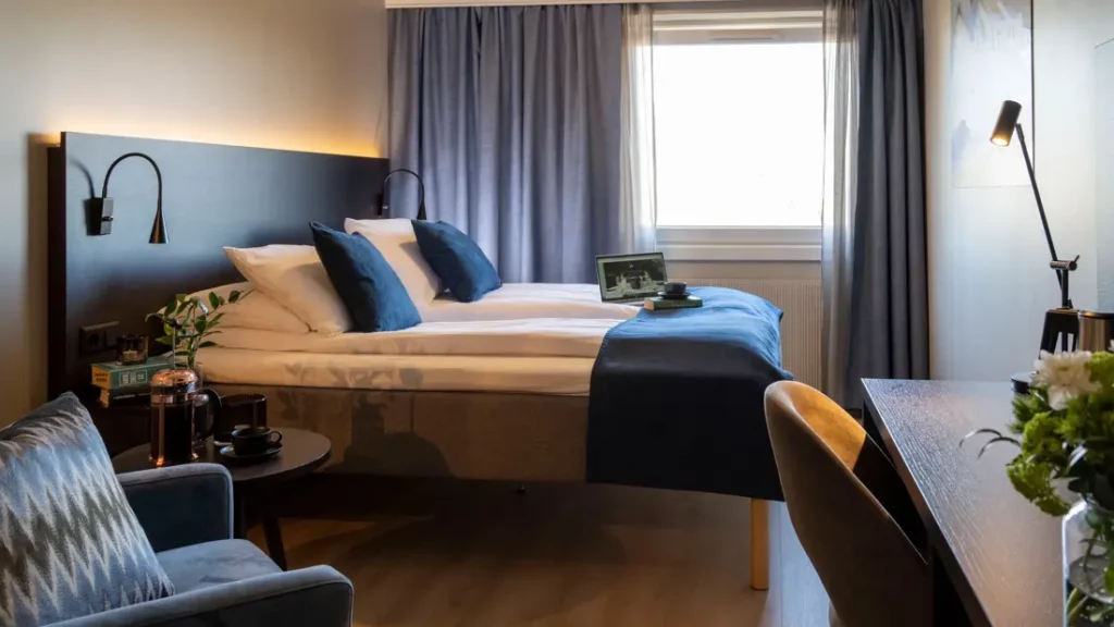 Tweepersoons hotelkamer met bureau, stoel en groot bed