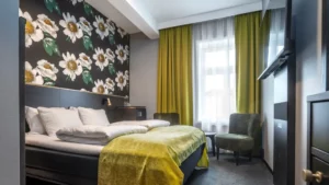 Moderne hotelkamer met tweepersoonsbed, fauteuil en daglicht