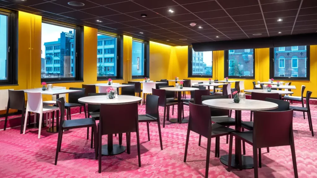 Moderne ontbijtzaal met ronde tafels, stoelen en grote ramen