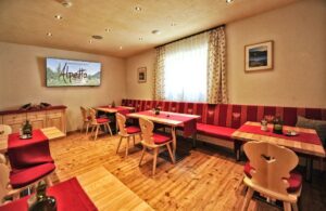 Restaurantzaal met houten tafels, banken en gedekte tafels