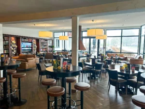 Lobby met tafels, stoelen en grote ramen