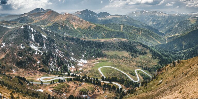 Panoramisch uitzicht op slingerende bergweg door heuvelachtig landschap