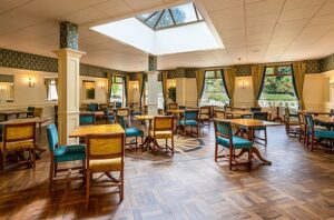Hotelrestaurant met ruime opstelling, tafels en veel daglicht