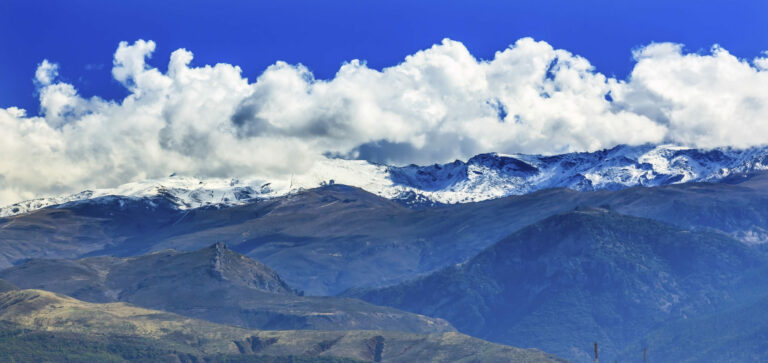 Berglandschap met besneeuwde toppen en wolken in de Sierras bij Sevilla