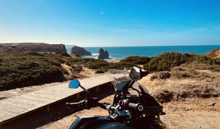 Motorfiets geparkeerd langs de Portugese kust met uitzicht op zee en rotsen