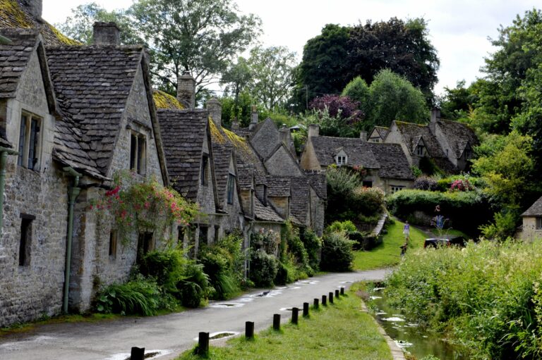 Smalle straat met natuurstenen huizen en veel groen in Cotswolds