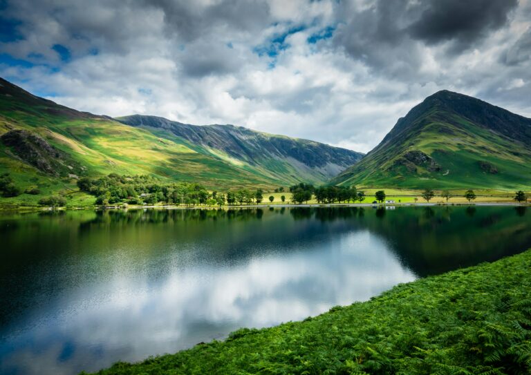 Bergmeer met reflectie en groene hellingen in het Lake District